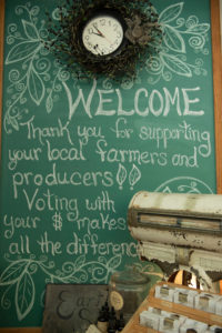 Chalkboard with the words "Welcome. Thank you for supporting your local farmers and producers!" Photo courtesy by Joe Klementovich Photography.